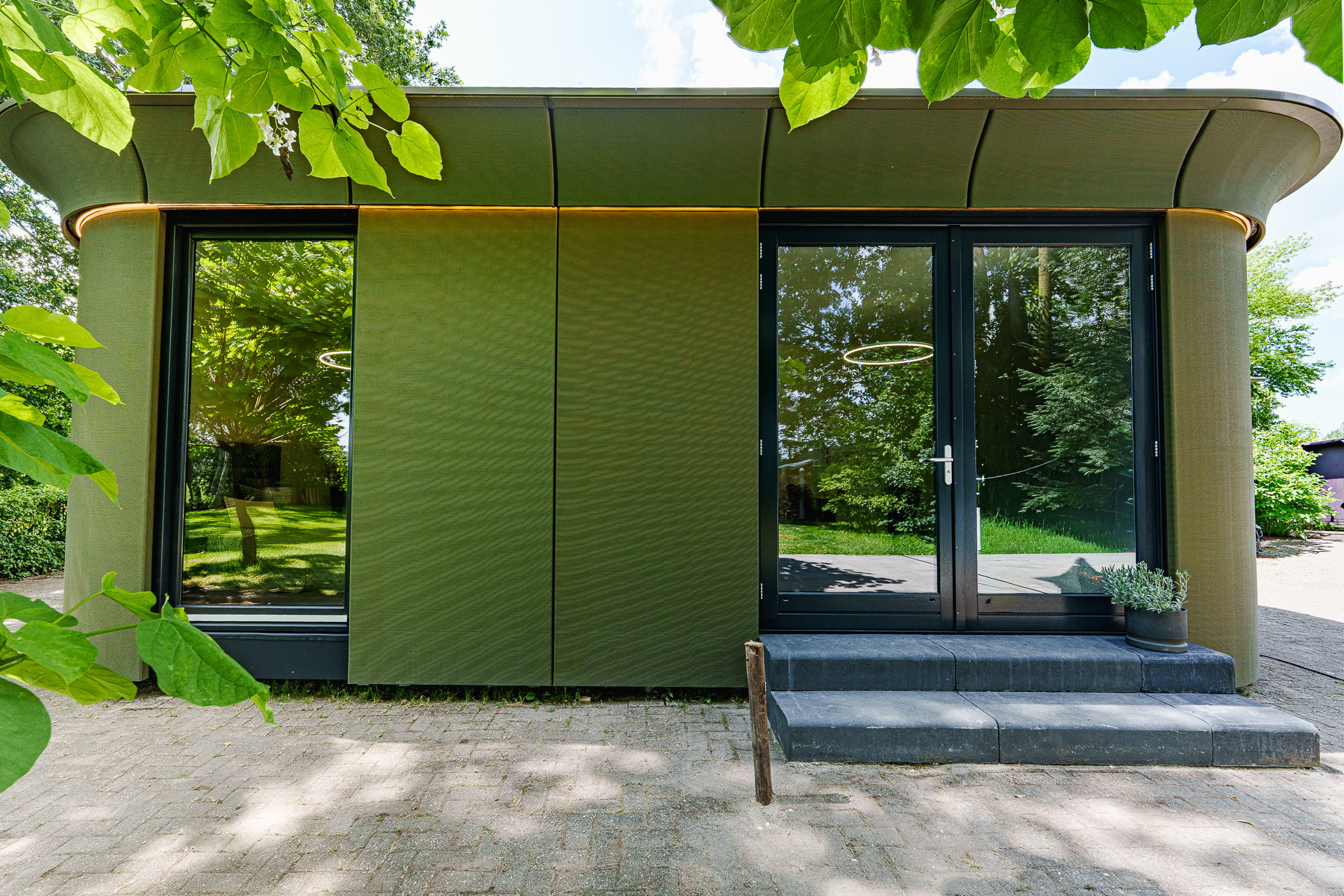 Silva Embrace 32 in Everdingen met groene gevel, glazen deur en bladerdak rondom de woning