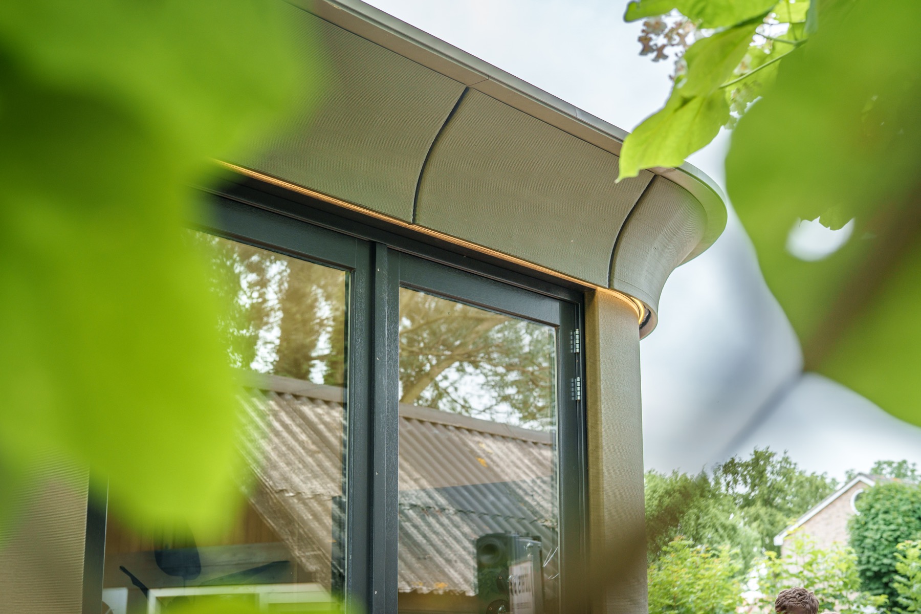 Dakrand en raamdetail van Silva Embrace 32 tussen groen blad